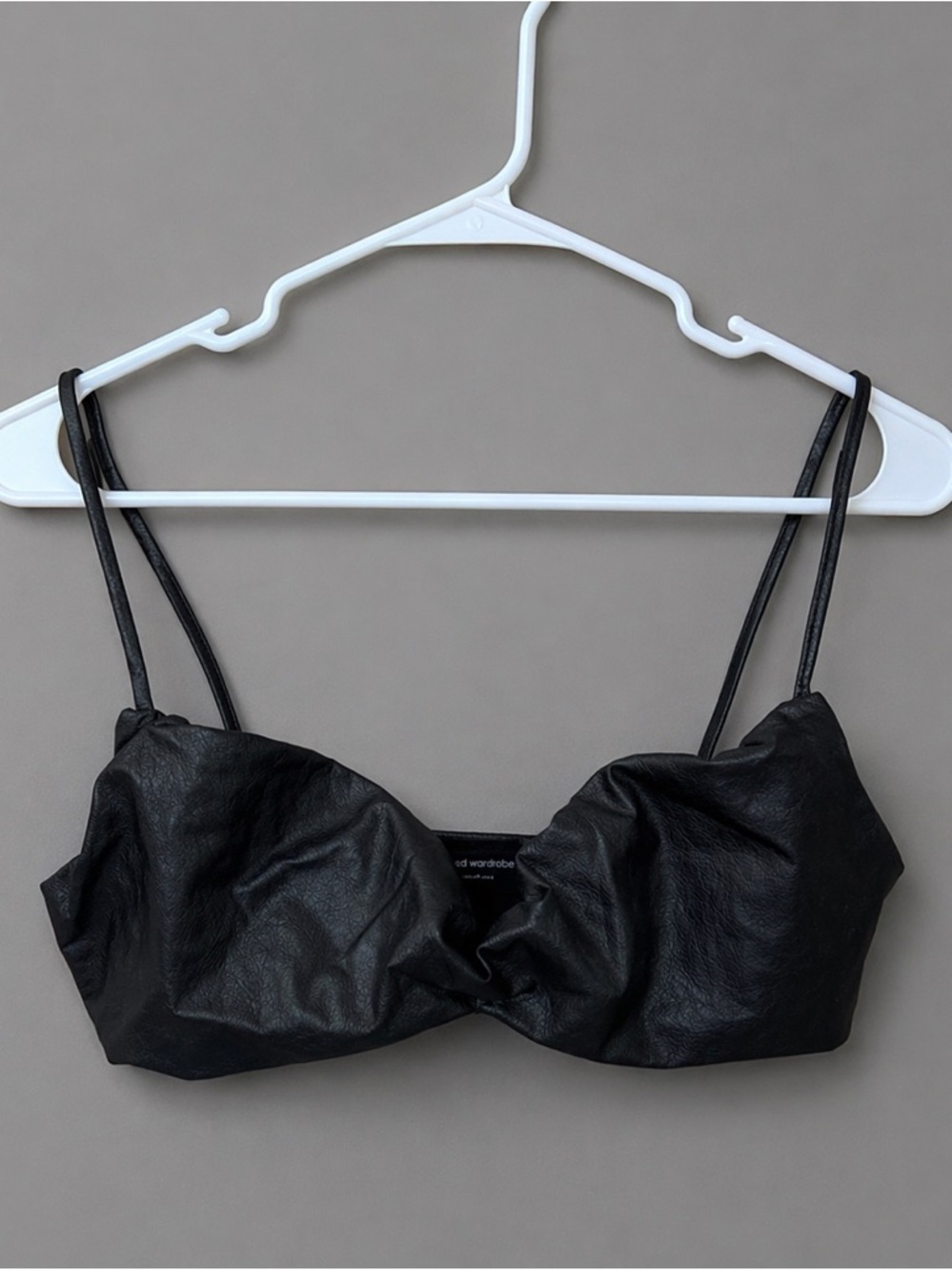 Naked Wardrobe black faux leather bralette.